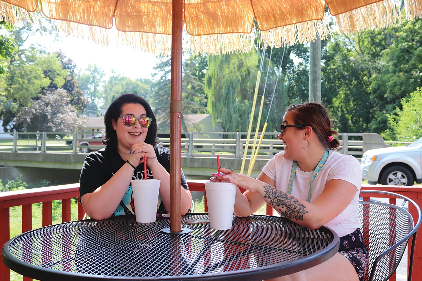Brianna Melvin, left, and Haleah Maddox enjoy drinks in the shade Monday at The Big Dipper.